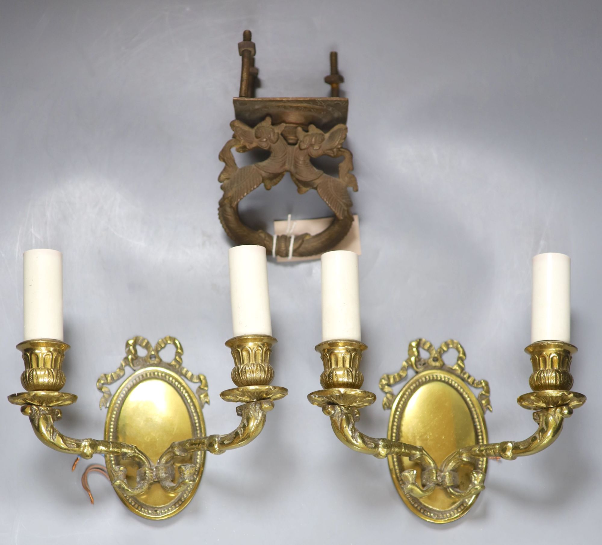 A pair of bronze two branch wall sconces, together with a South East Asian dragon door knocker